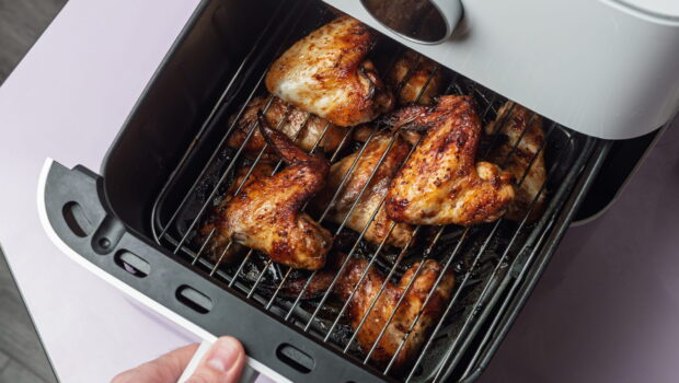 hand-pulls-air-fryer-basket-with-glossy-roasted-ch-2026-03-05-11-38-45-utc